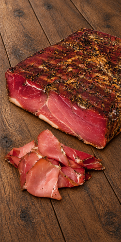 Palatin Feketekői sonka Hungarian ham, shown whole and thinly sliced on rustic wood. Explore Hungarian deli meats at OstryStefek.pl.