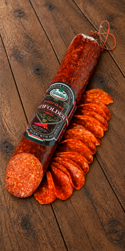 Ostre salami paprykowe Palatin Paprikás Stifolder w kawałku i plastrach na rustykalnym drewnie. Poznaj węgierskie wędliny w OstryStefek.pl.
