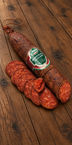 Palatin Mangalica Szalámi pork salami on rustic wooden boards, with a visible cut end and thin slices in the foreground.