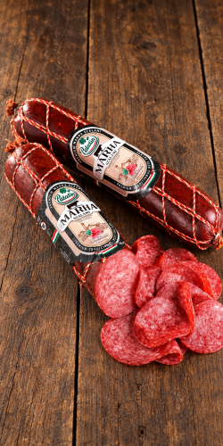 Węgierskie salami wołowe Palatin Marha szalámi z widocznym przekrojem i cienkimi plasterkami, przedstawione na ciemnych rustykalnych deskach.