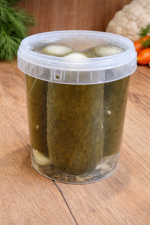 Product photo of Hungarian pickled cucumbers stuffed with sauerkraut in a glass jar, preserved in vinegar brine, unpasteurized, showing natural texture and traditional packaging.