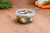 Hot pickled cherry peppers stuffed with garlic in a plastic bucket, traditional Hungarian unpasteurized vegetable pickle.