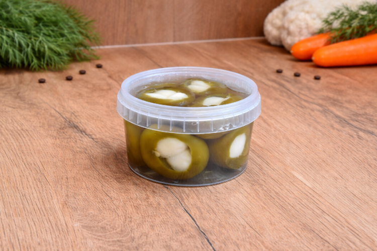 Ostra papryka czereśniowa marynowana nadziewana czosnkiem w plastikowym wiaderku, tradycyjny węgierski pikiel warzywny.