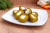 Hot pickled cherry peppers stuffed with garlic on a plate, traditional Hungarian unpasteurized vegetable pickle.