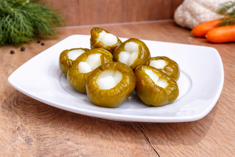 Ostra papryka czereśniowa marynowana nadziewana czosnkiem w plastikowym wiaderku, tradycyjny węgierski pikiel warzywny.