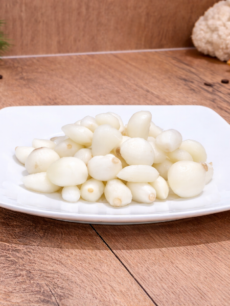 Czosnek marynowany z Vecsés podany na talerzu jako tradycyjny pikiel.