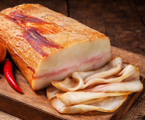 Hungarian smoked and dry-aged Mangalica pork fat – traditional artisanal delicacy with a creamy texture and rich natural smoke aroma. Presented on a rustic wooden board, perfect for serving with fresh bread and classic European appetizers.