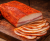 Hungarian Mangalica paprika lard, dry-cured and smoked, styled in a rustic setting. Lightly dusted with finely ground paprika, with a delicate texture and rich aroma—traditional premium charcuterie.