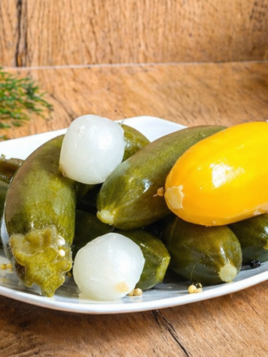 Hungarian mini zucchini pickled in vinegar with onion, mustard, coriander, and spices.